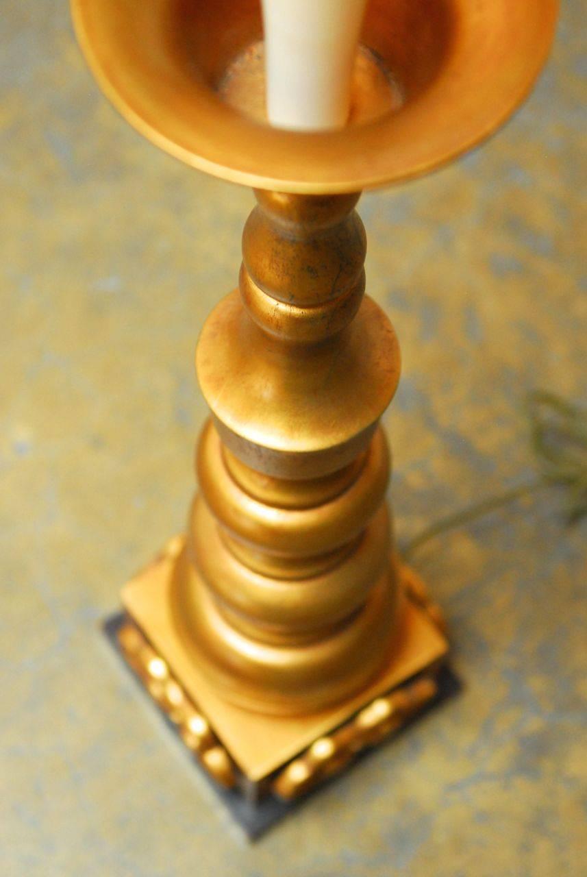 Fantastic hand-gilt lamp featuring a turned wood pagoda or baluster form column with a wood base and applied gilt ruyi clouds. Excellent styling, matching Indian and Chinese decors. Includes gilt finial over brass metal double head fixture with