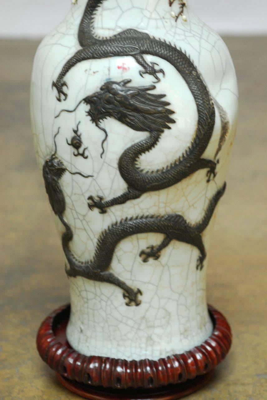 Seltene glasierte Vase aus der Qing-Dynastie des 19. Jahrhunderts mit Craquelé-Glasur (GE) und geformten dreidimensionalen Drachenformen. Diese Vase von sehr guter Qualität ist besonders interessant, weil sie einen Brennfehler aufweist, der der
