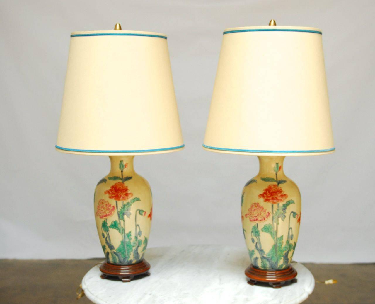 Pair of chinoiserie decorated Marbro ceramic lamps. Excellent quality European vases mounted with walnut bases. Decorated with flowering chrysanthemum blossoms, buds, and leaves. Included original matching shades and finials.