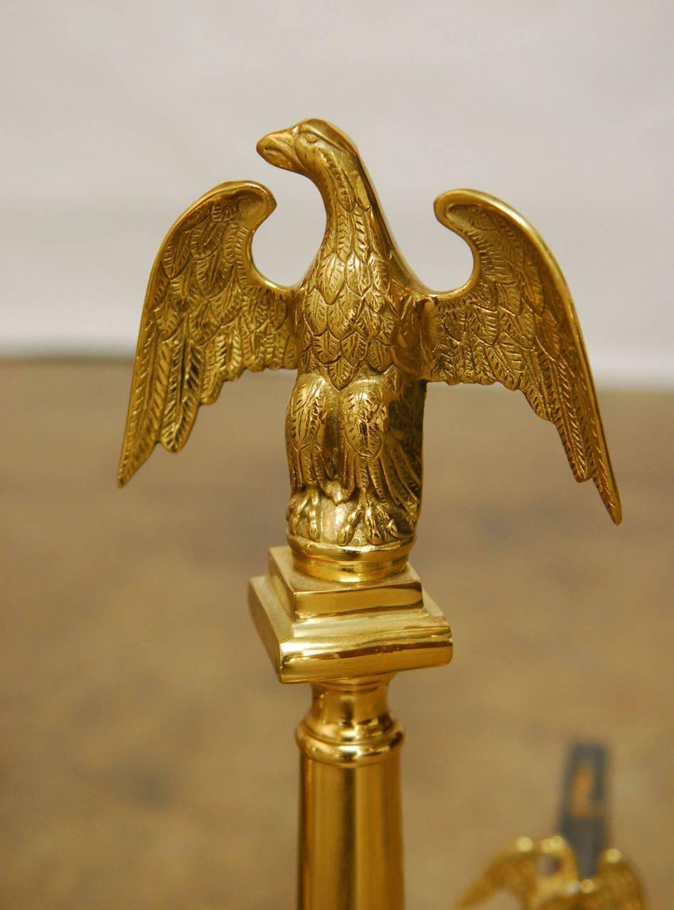 This pair of elegant andirons feature two sculptural eagles on each andiron. One large finial and a smaller eagle on the log rest arm. Supported by eagle ball and claw feet.