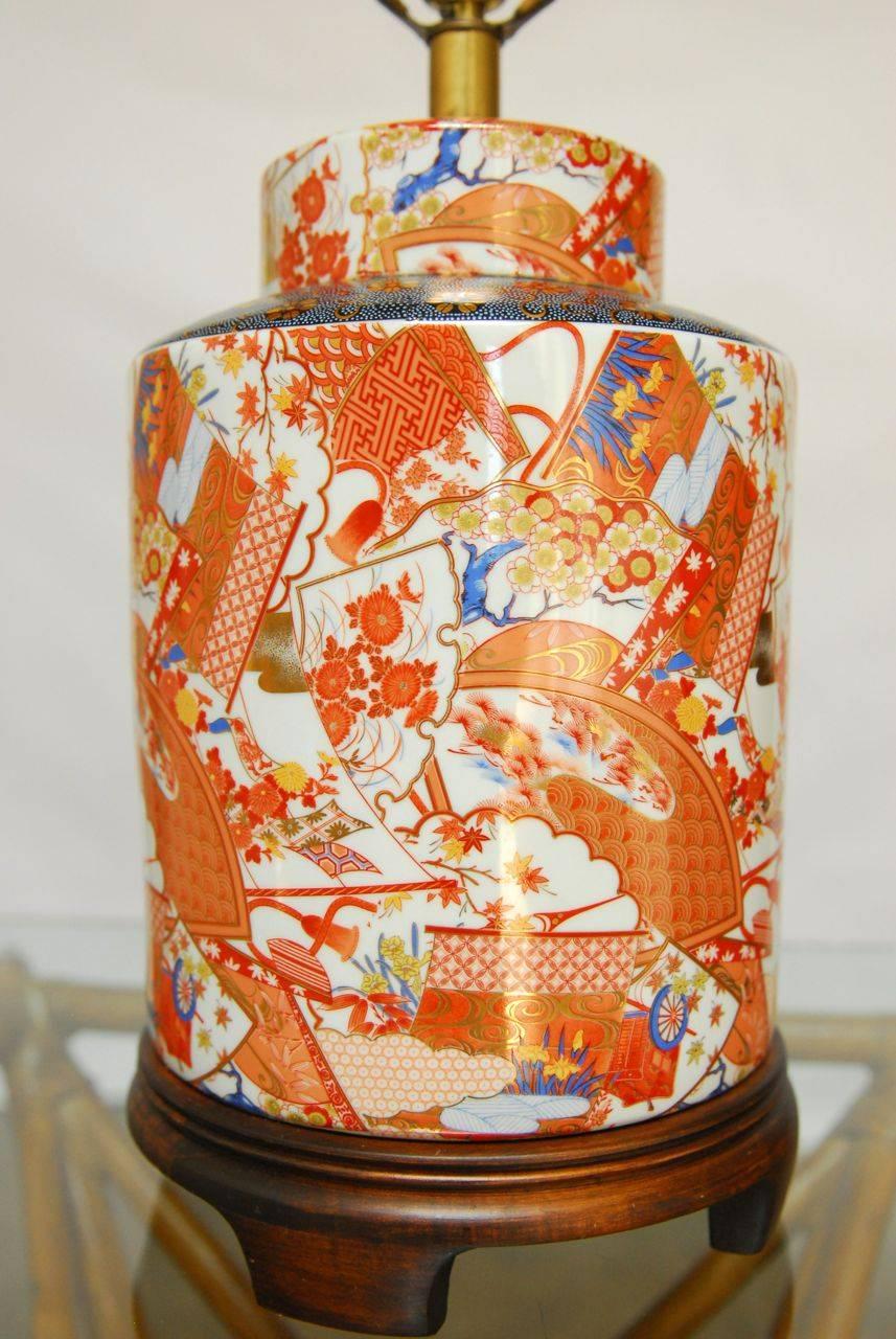 Beautiful enamel and gilt ceramic tea canister mounted as a lamp with a solid walnut Asian style base. Produced by Frederick Cooper of Chicago. Includes prosperity motif finial and no shade.