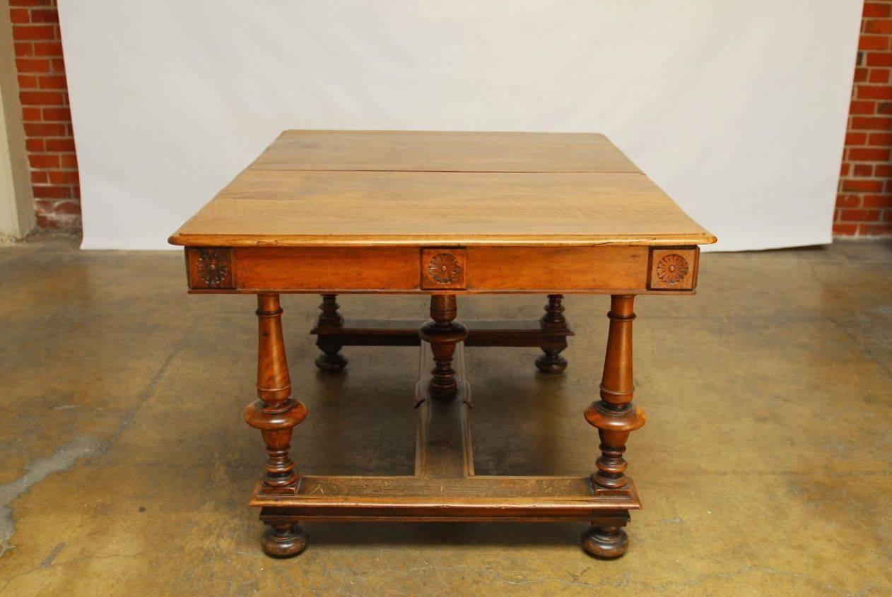 Stunning and rare example of a Louis XIII refectory or dining table with strong hand-carved base and floral medallions on the frieze. Featuring a magnificent age defined French oak plank top. Table has very minor cracks and old repairs as expected