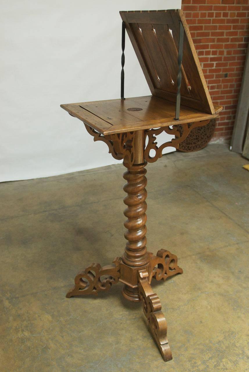 Large Italian Gothic church lectern made of hand-carved wood featuring a large rotating top section with scrolled supports atop a huge barley twist column. Supported by a scrolled tripartite base, this impressive display piece would be perfect in a