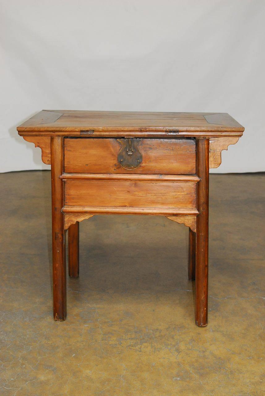 Handsome Chinese altar table coffer fronted by a single drawer with a large metal brass lock plate. Features mortise and tenon joinery with straight legs and decorative spandrels. Mixed Chinese hardwoods with a warm patina.