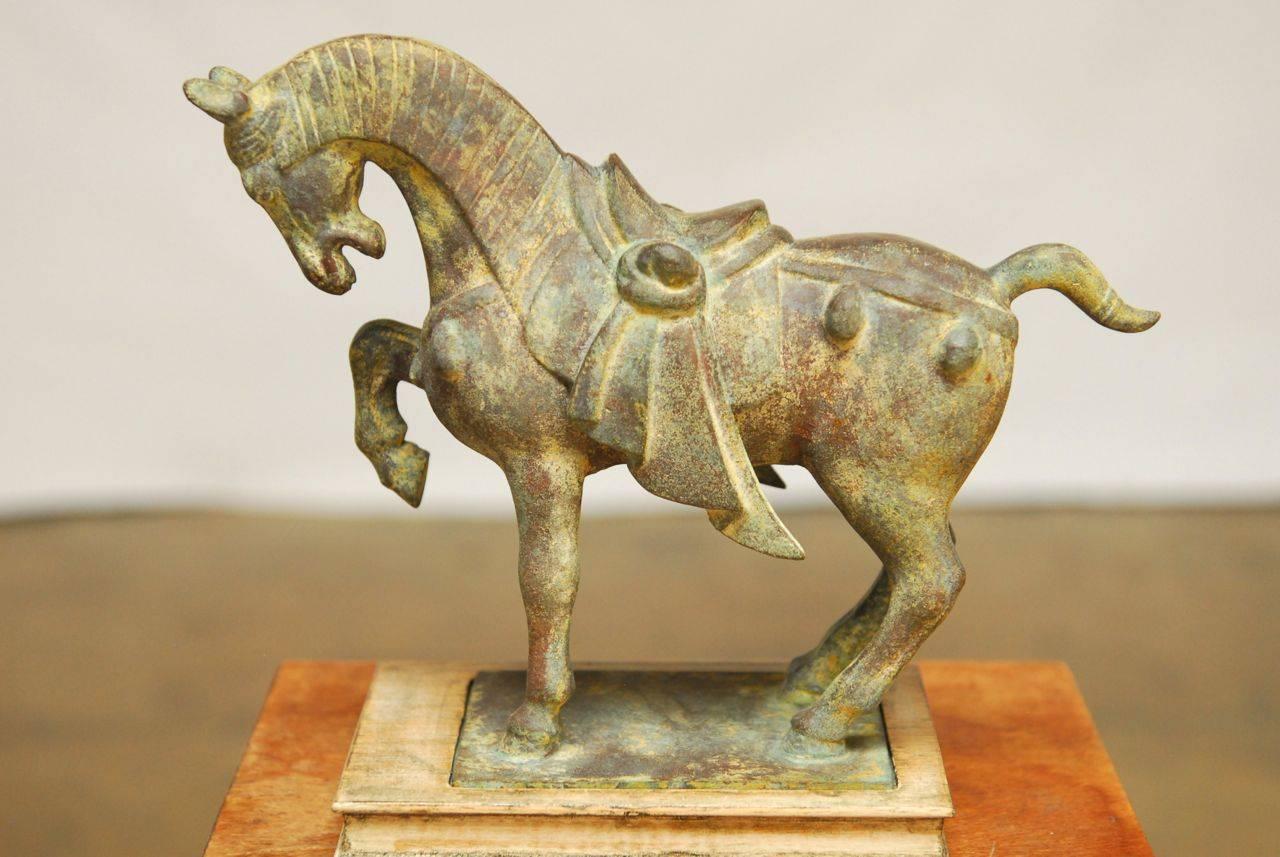 Exquisite cast iron sculpture of a Chinese lacquer war horse made in the Tang style. Mounted on an iron base with a fitted wooden pedestal. Lovely patina on the vintage metal.