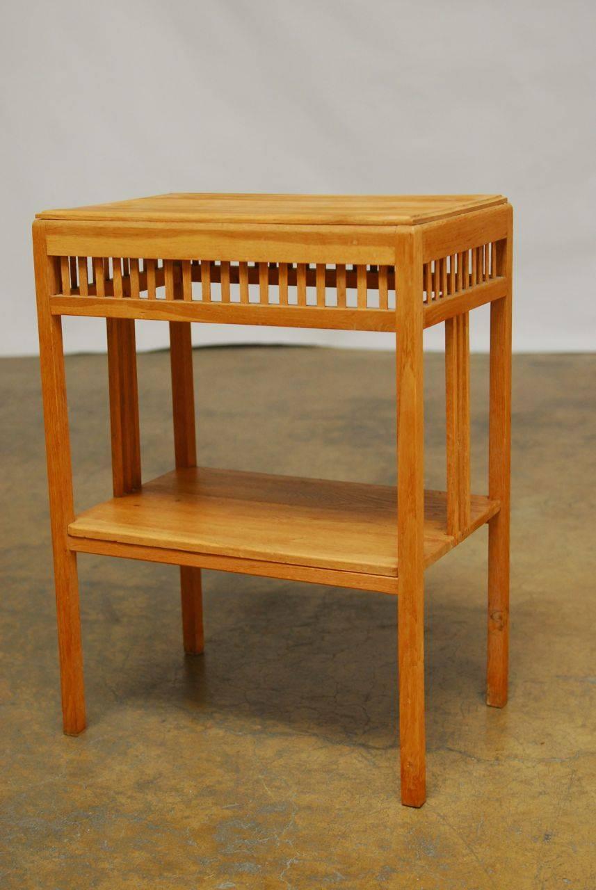 Elegant oak side table by Jeffrey Alan Marks executed in the Rennie Mackintosh taste with a rectangular top above match stick supports. Two-tier design supported by simple square legs.