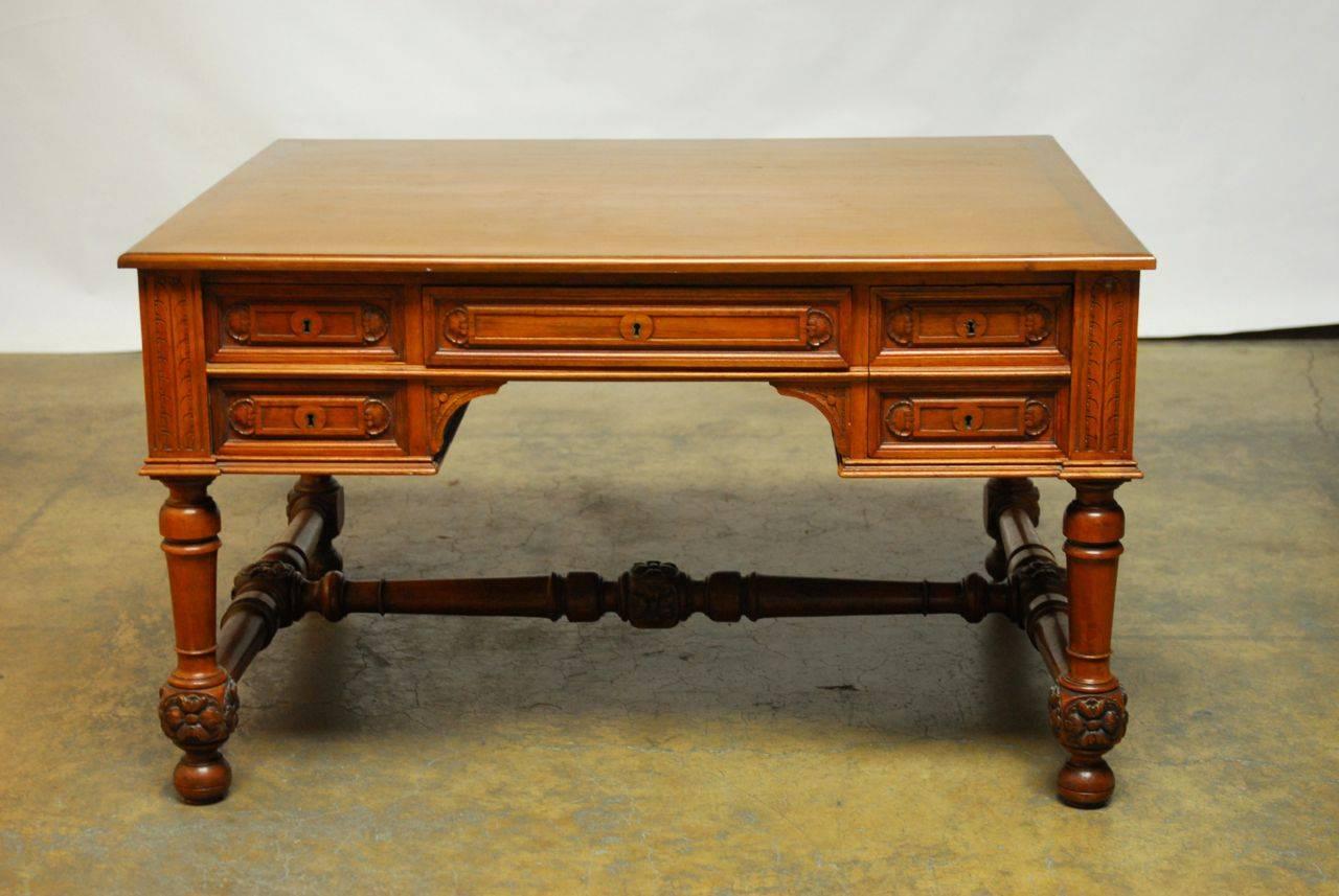 Remarkably large writing table made in the Louis XIII taste with a generous size case and supported by thick turned legs and stretchers decorated with rosettes. Four large deep locking drawers and a hidden secret lock box inside the largest drawer.