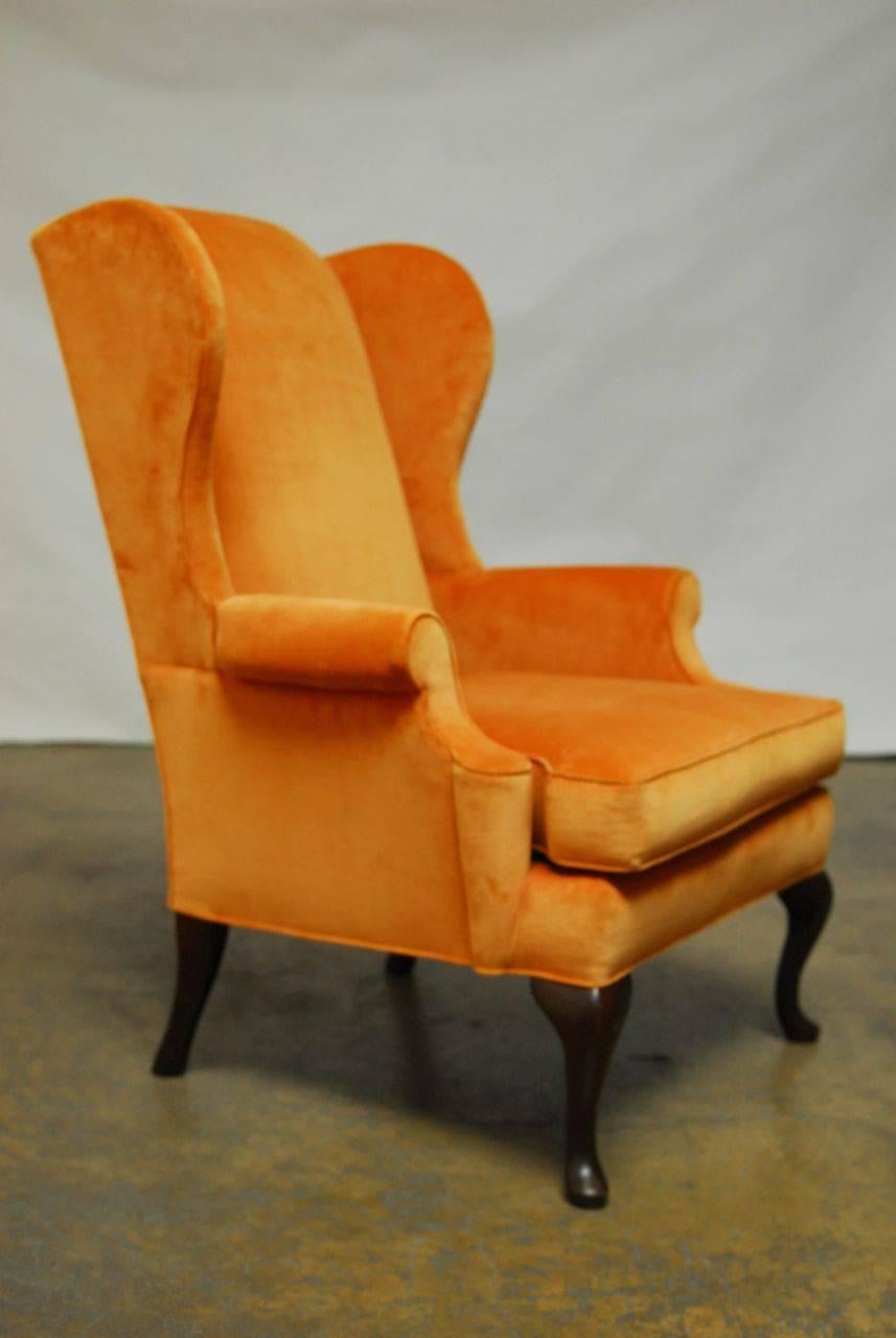 Stunning pair of velvet wing backs featuring an orange sherbet velvet upholstery. Custom ordered and made by Pearson company with dark espresso colored cabriole legs. Very comfortable with generous proportions.