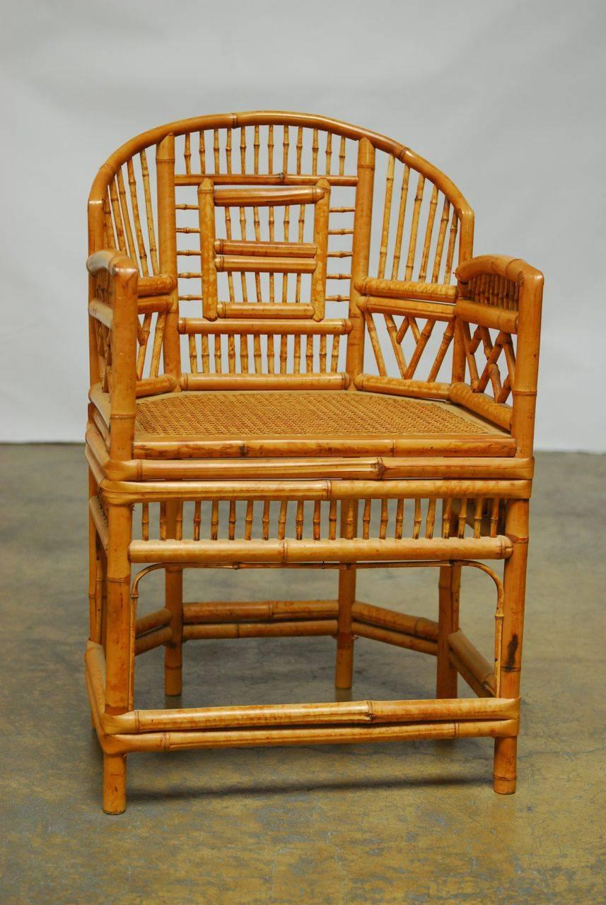 Fabulous bamboo armchair made in the Brighton Pavillion style with open fretwork back and a cane seat. Lovely patina and color on the vintage rattan and bamboo.