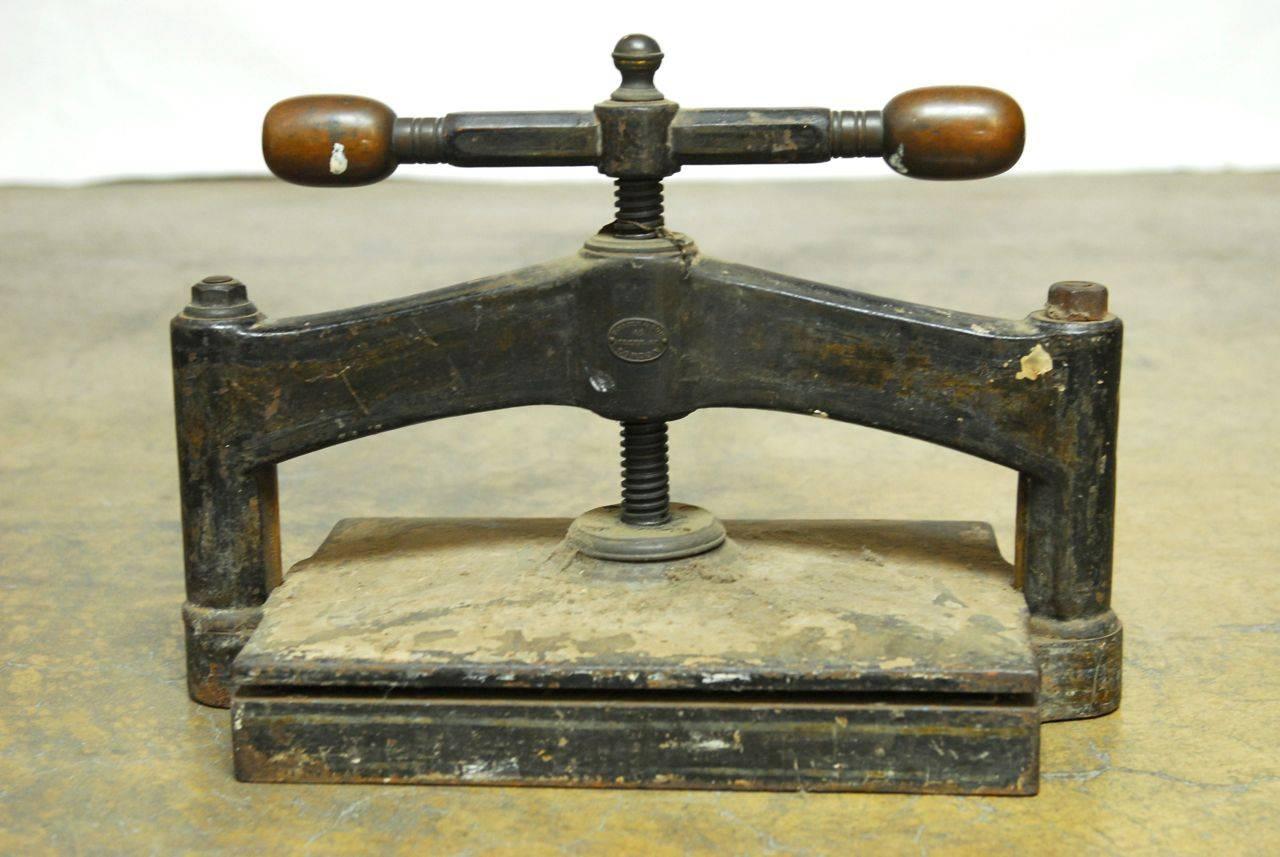 Remarkable English book press made by Hooper and Sons London, England. Solid cast iron construction that weighs 200 lbs. with rounded wooden handles. Makers label on front. Very impressive Industrial piece.
