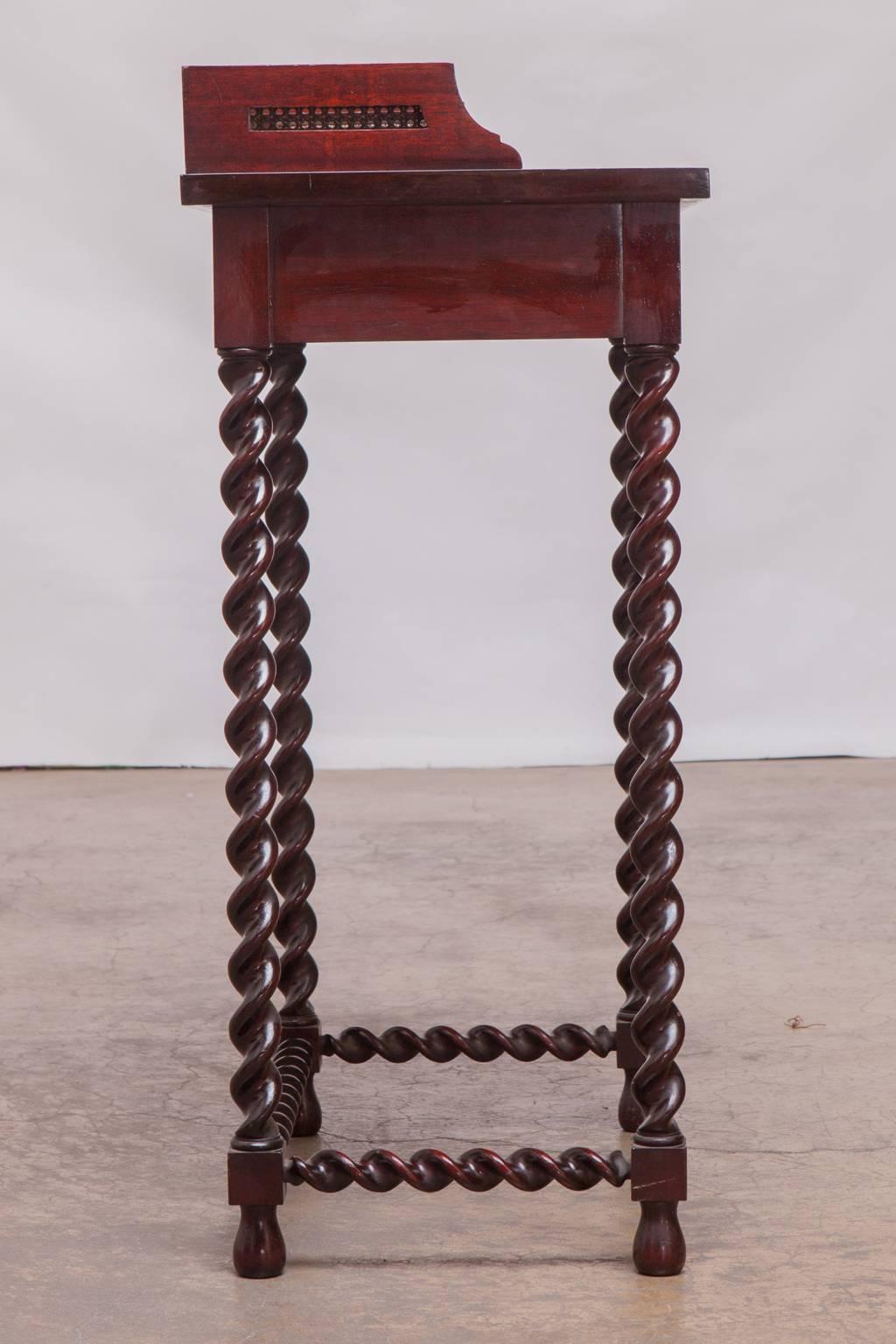 Rare mahogany small writing table or telephone table featuring long barley twist legs and stretchers. Galleried top with a decorative cane insert and small bookshelf underneath. Small enough to fit just about anywhere from an old interior decorator