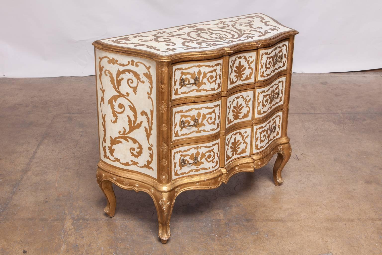 Lavish Italian chest of drawers made in the Florentine or Venetian style with gilt decoration and foliate motif. Fronted by three large drawers with metal pulls and supported by cabriole legs.