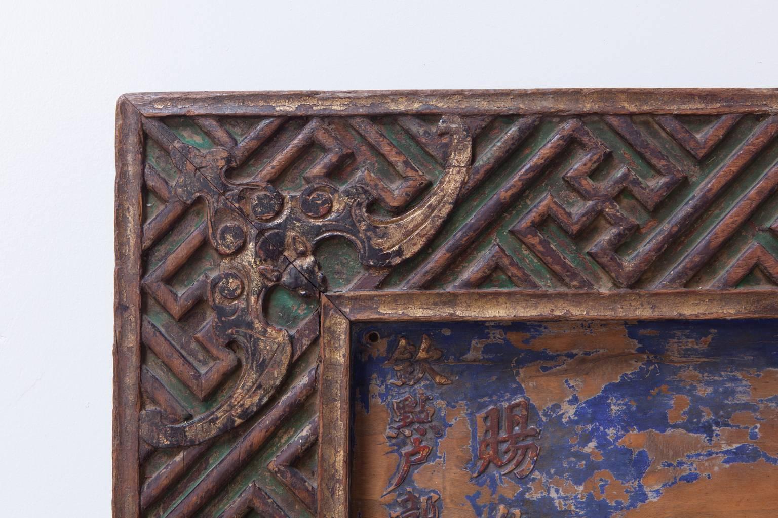 Remarkable Chinese honorary plaque featuring a large four character inscription and intricately carved geometric wan fret border with bats on all four corners and center. Traces of green lacquer pigment color still remain on borders with blue and