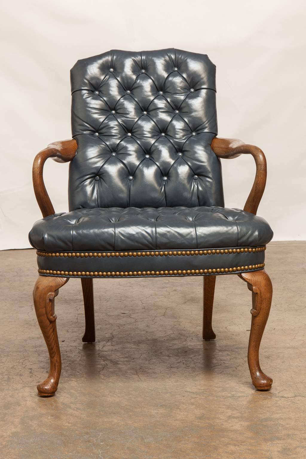 Impressive leather library chair featuring French blue tufted upholstery accented by brass nailhead trim. Supported by cabriole legs with pad feet this chair was made by Schafer Brothers and has a matching executive office desk chair also available.