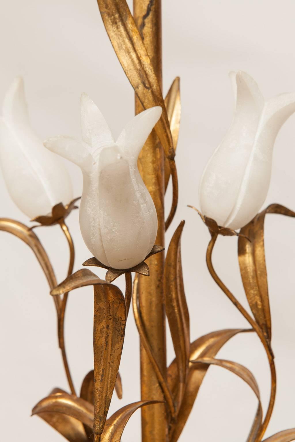 Charming gilt metal table lamp featuring carved alabaster flowers and vase on a shaped giltwood base. Whimsical flowing foliate and scrolls climb up the column and terminate with a large gilt finial. Shade not included. Made in Italy in the