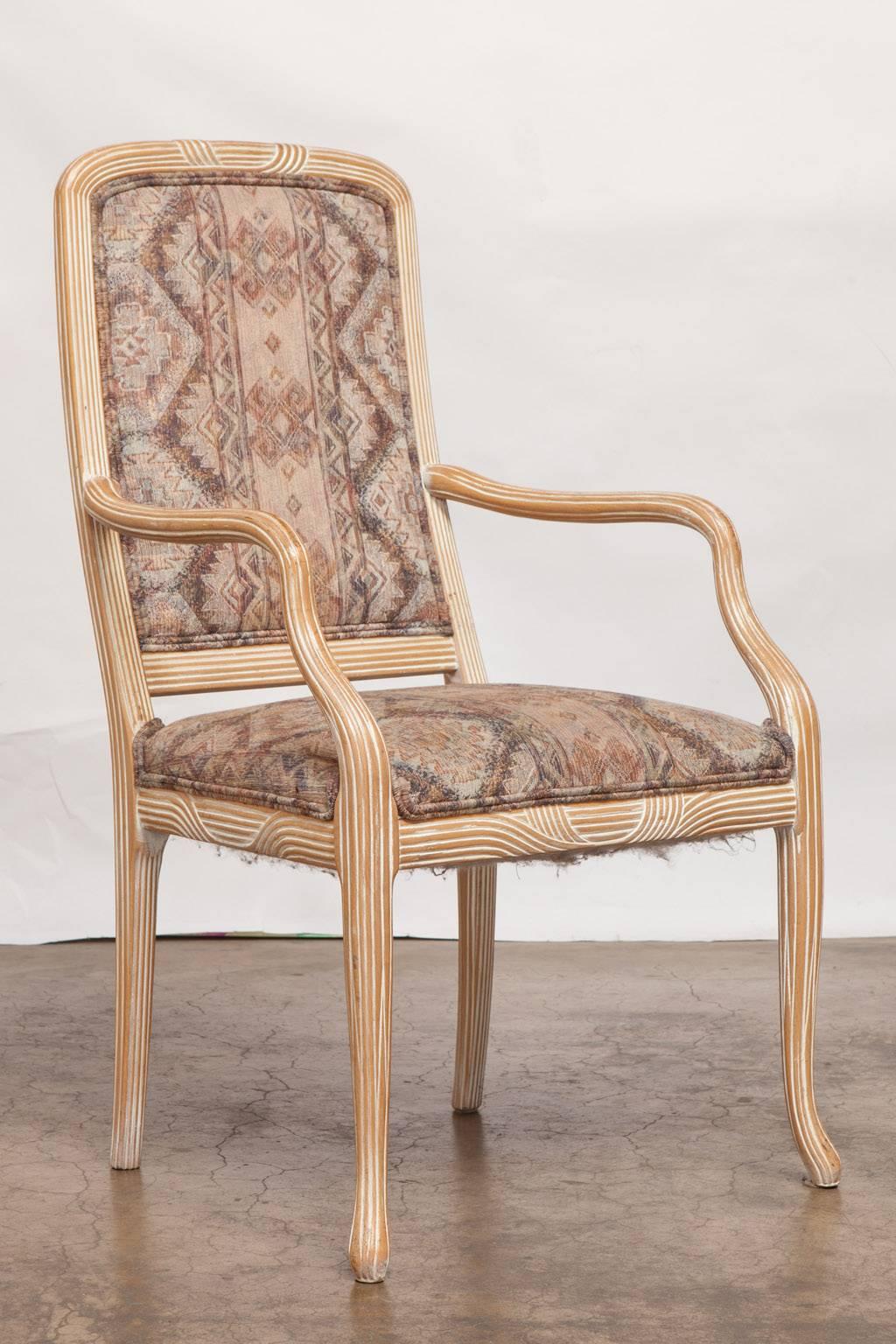 Unique set of dining armchairs featuring a cerused whitewash oak finish on a reeded frame. The carved frames have graceful curved arms with a natural form. The chairs are supported by reeded splayed legs. Original 1980s upholstery could be updated