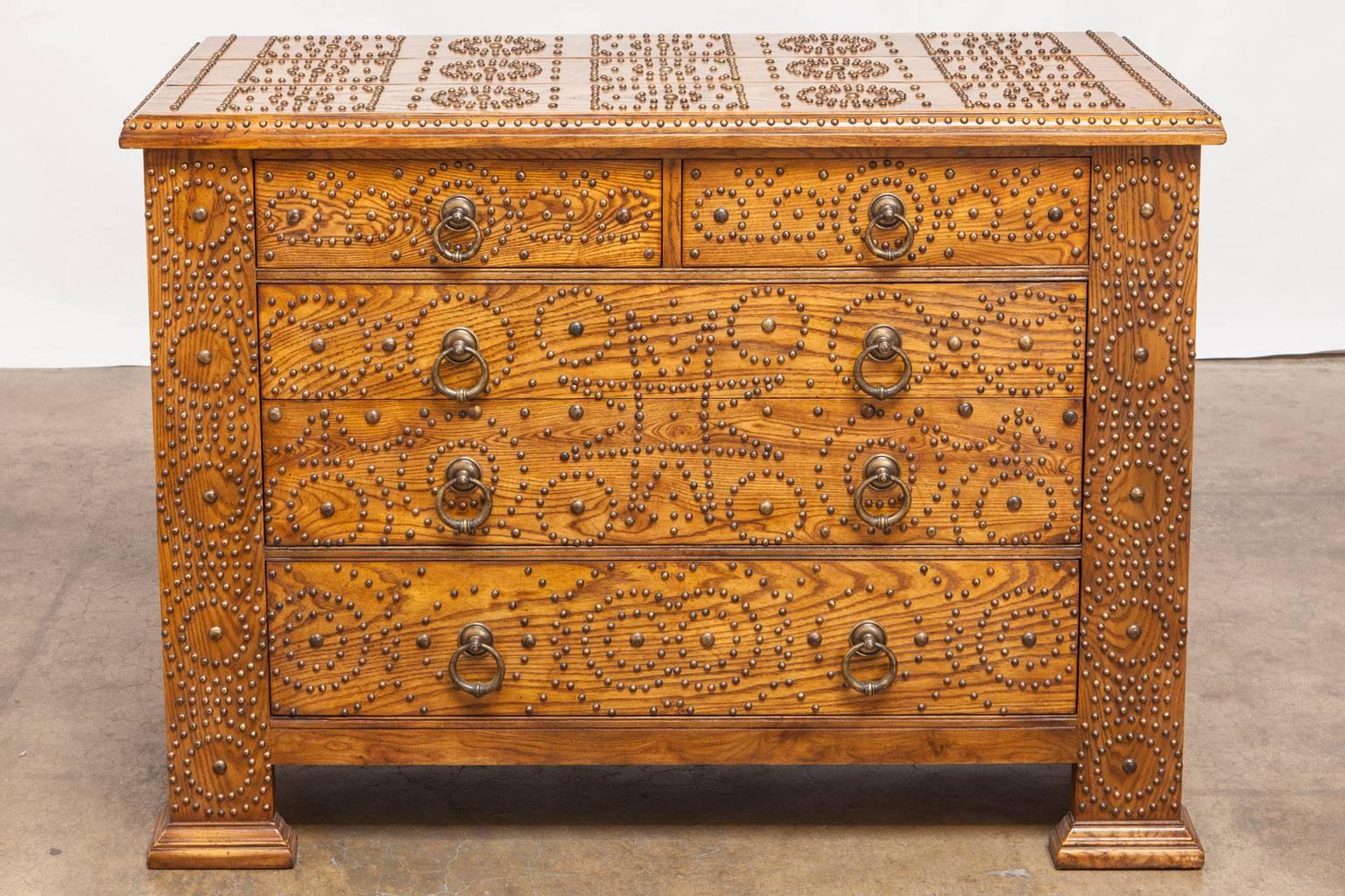 Fantastic oak chest of drawers featuring large brass studs decorating four sides with solid brass ring pulls. Fashioned after an African zanzibar strongbox chest, or dowry trunk this labor intensive style has a unique Folk Art whimsical look.