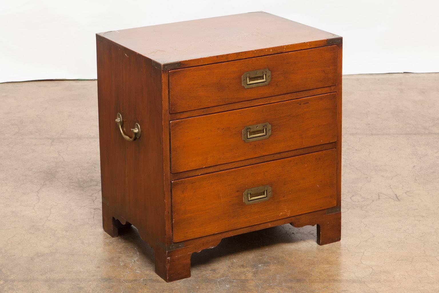Diminutive English mahogany brass-mounted Campaign chest featuring three drawers with flush brass handles and larger handles on each side. This small chest of drawers or commode would make a great nightstand or bedside table. In found condition with