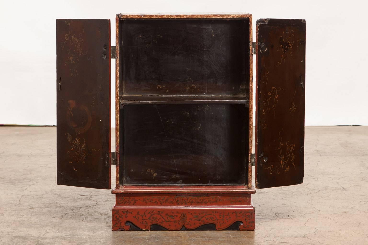 Remarkable pair of matching diminutive Japanese storage cabinets featuring a thick coromandel style lacquer base with finely painted idyllic scenes. Accented with gilt trim and brass hardware plates. Decorated on four sides and the interior, these