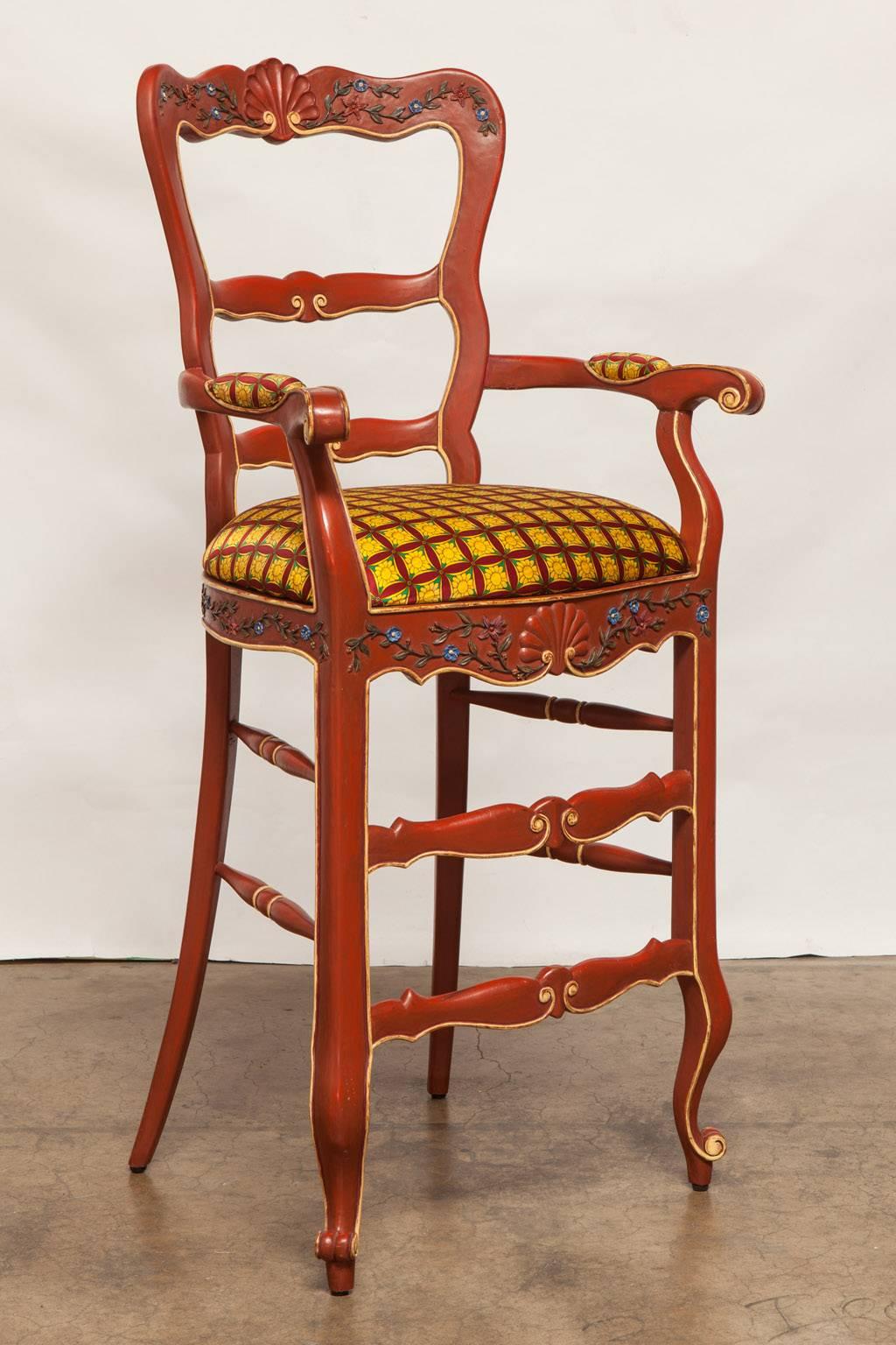 Rare pair of French country relief carved bar stools made in a Provincial style with a wide seat and back. Whimsical hand-carved cabriole legs and scroll arms with a frame decorated with foliate detail and a shell crest and apron. Bright red lacquer