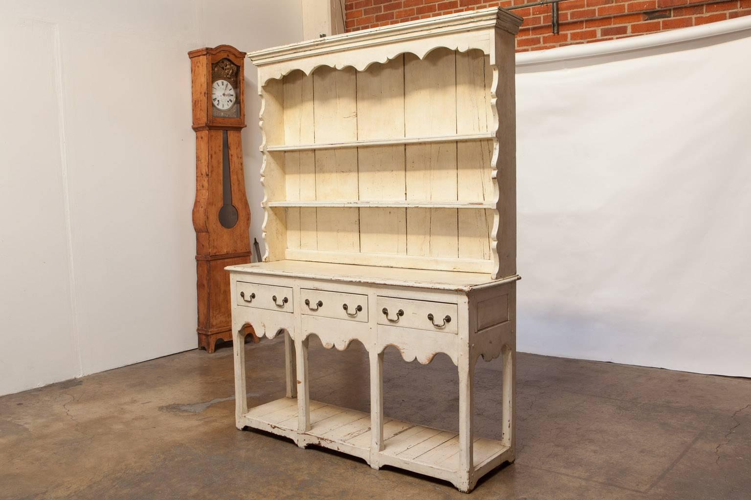 Rare Welsh dresser with a pot board base and an upper section having a molded cornice above a two shelf rack. The lower section is fronted by three drawers and a shaped apron. Supported by chamfered straight legs. The cupboard is constructed with