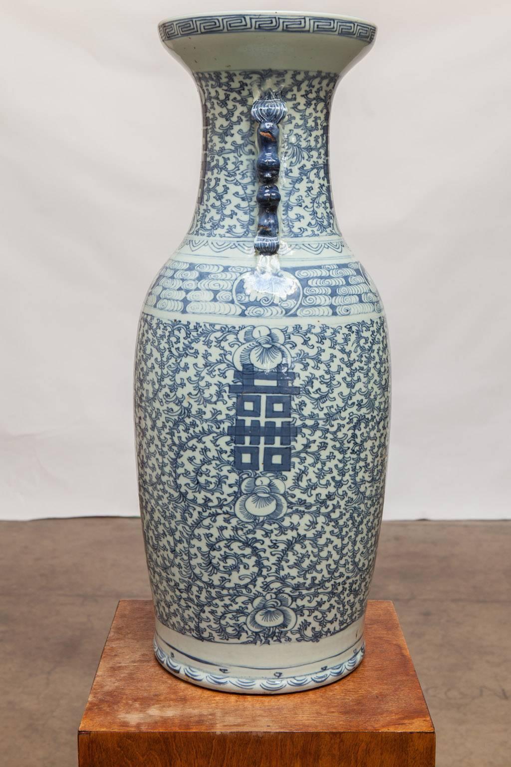 Lovely 19th century Chinese blue and white porcelain handled vase decorated with double happiness characters amidst a busy background of leafy floral scrolls. The neck is flanked by pairs of foo dog or foo lion.