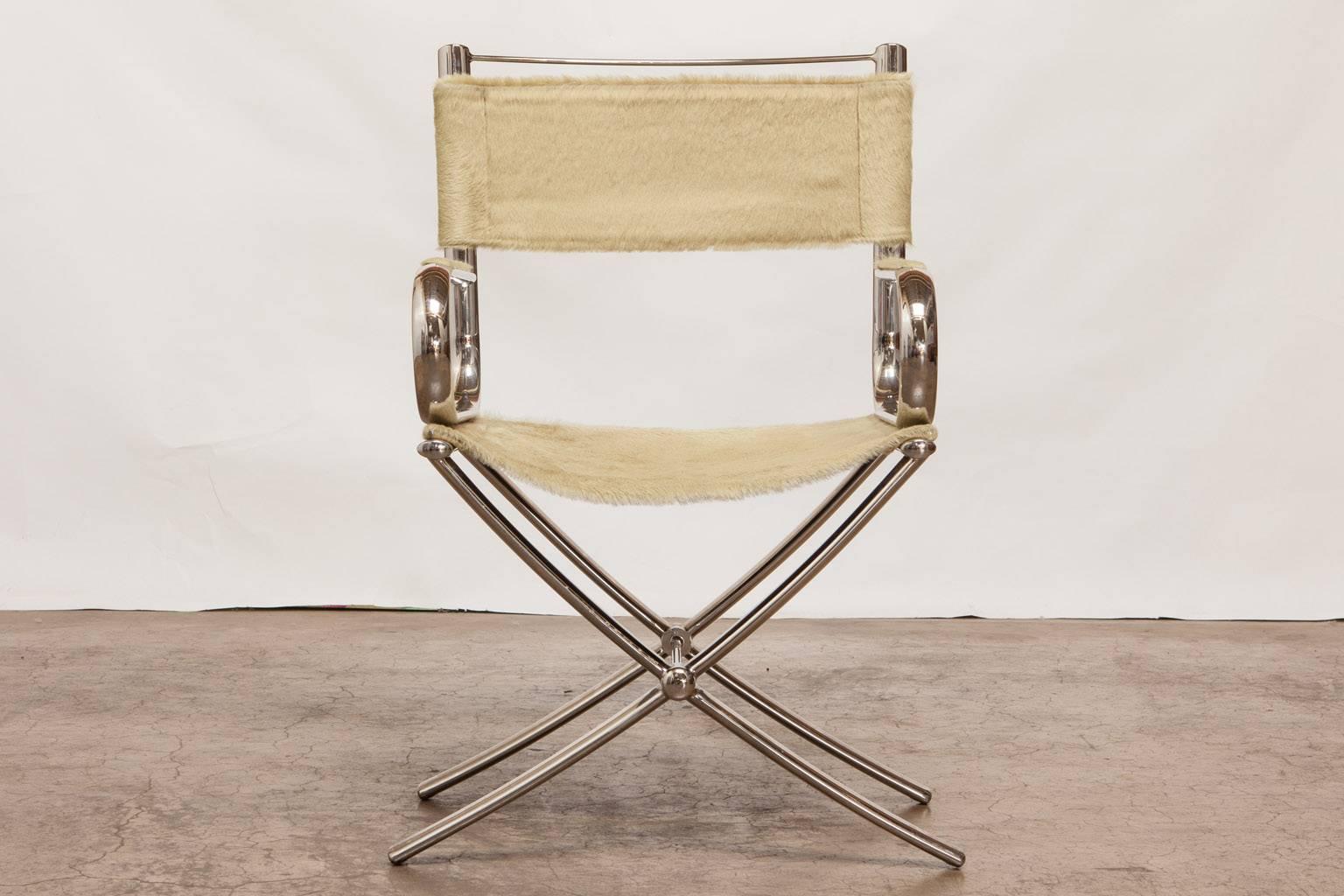 Chic chrome director's chair by Eric Brand featuring a light colored cowhide saddle and back. Designed to commemorate the architect Phillip Johnson with styling cues from his functionalist work. Made in the manner of Alessandro Albrizzi's Italian