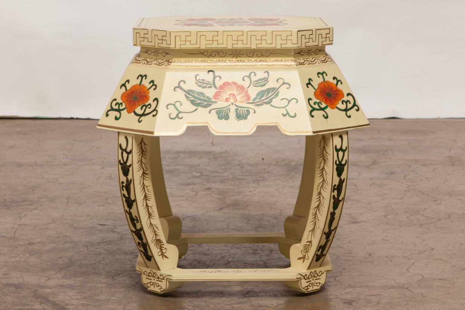 Colorful Chinese garden stool or plant stand featuring a cream ground with hand-painted floral and foliate decoration with gilt accents. Supported by four curved legs and a box frame base under a large shaped apron. This would also make a great