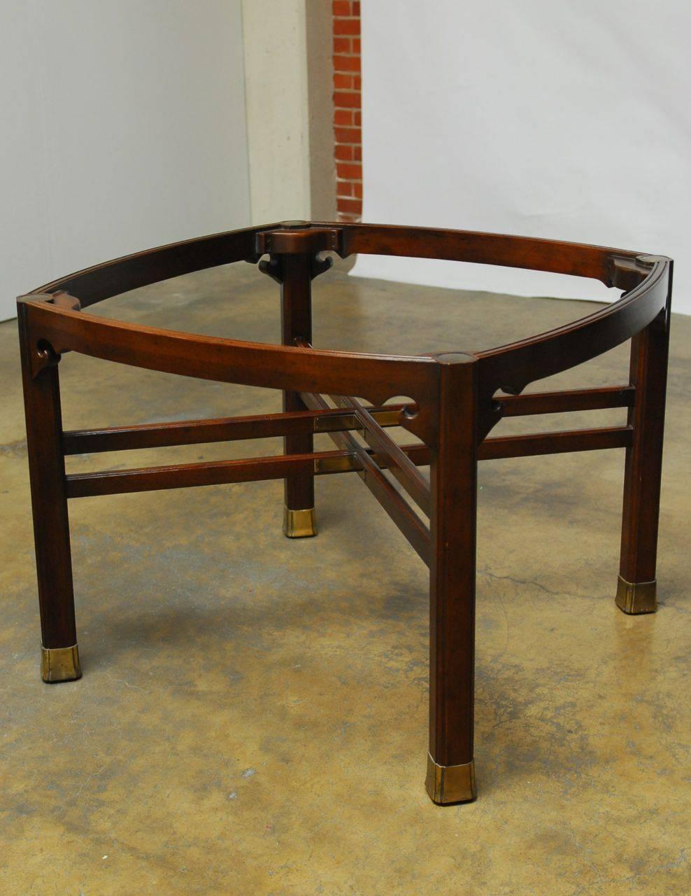 Exquisite Chinese ming style dining table by Henredon. Constructed from mahogany featuring cross stretcher supports with brass plates and cloud motif spandrels. Supported by thick reeded legs with brass foot protectors. This unique table has a