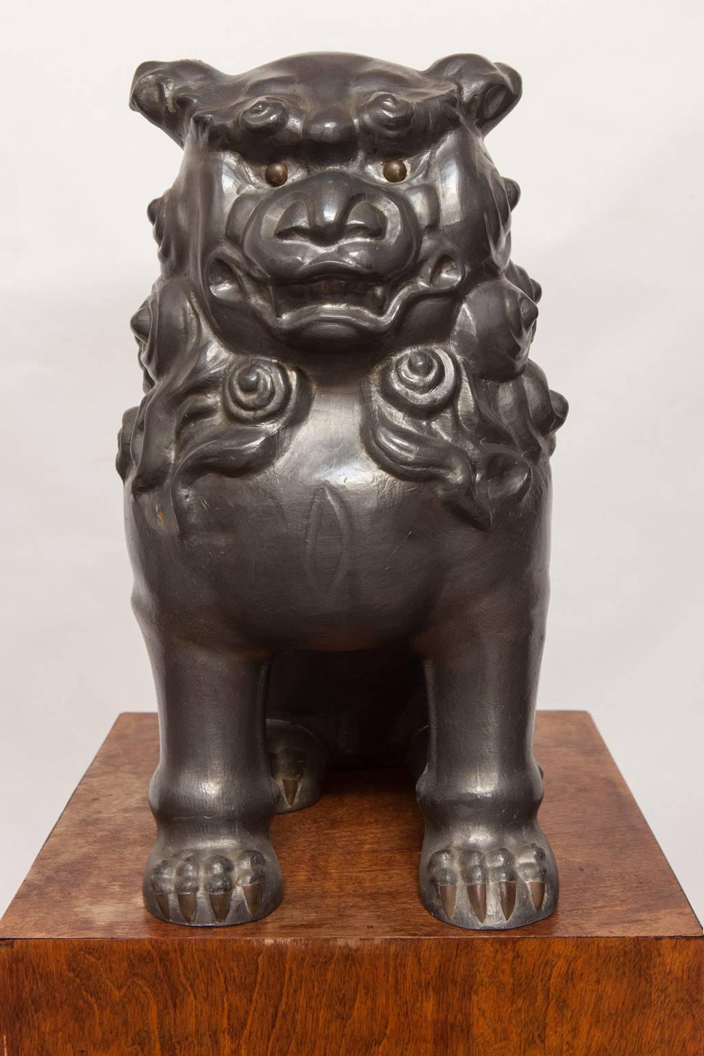 Rare pair of Chinese foo dogs or foo lions constructed from pewter. Very heavy and solid originally made to support a thick glass top for a coffee table. These temple guardians have a fierce look with bronze eyes and claws.
