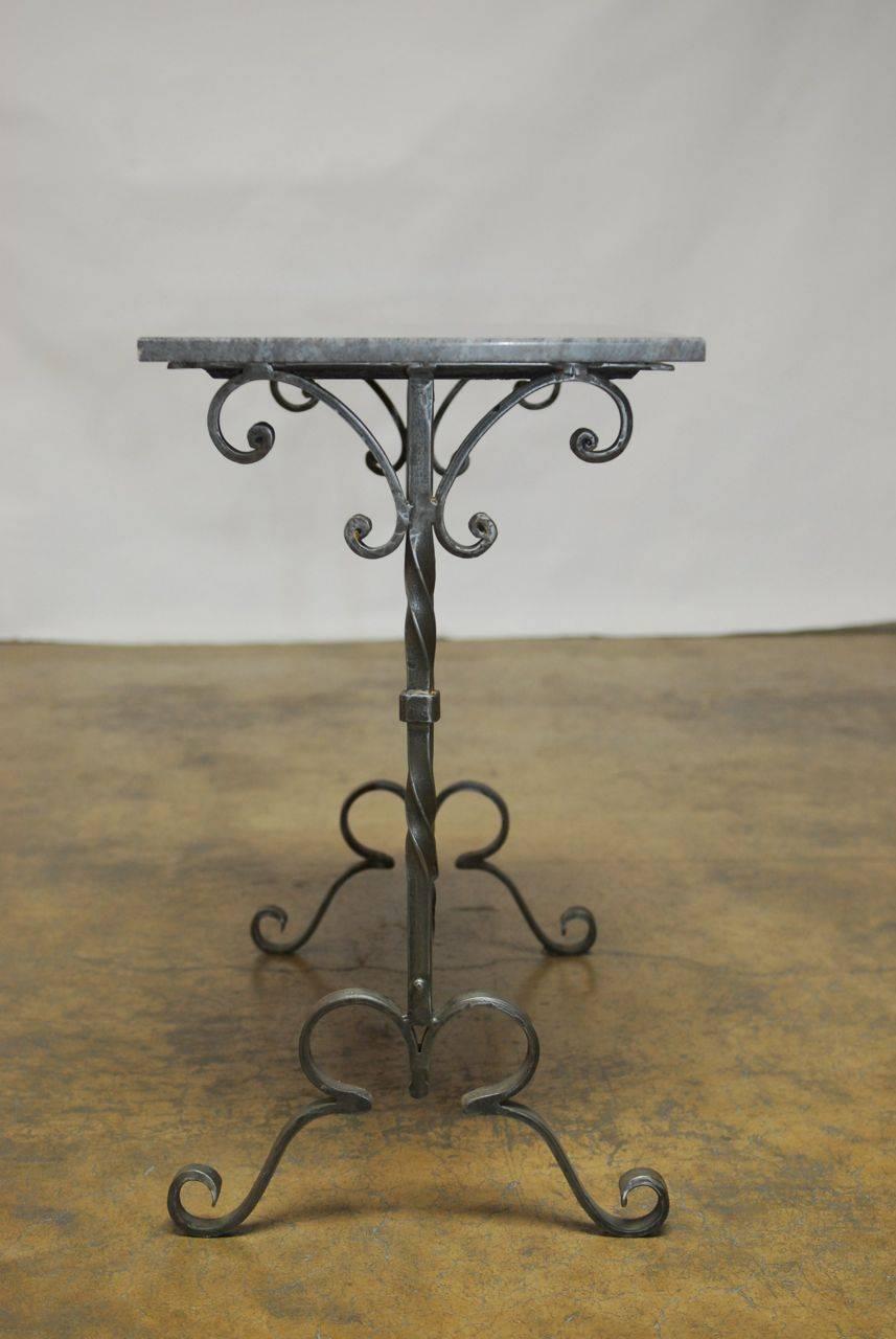 Distinctive wrought iron console table featuring a rectangular marble-top. The iron base is made of decorative scroll shaped spandrels and feet. 