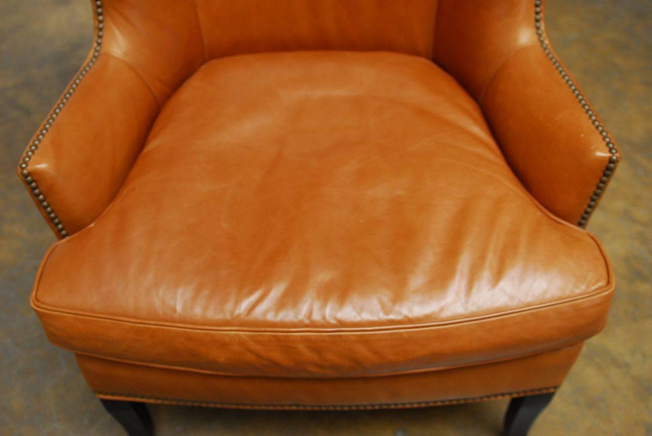 Sensational leather butterfly wing chair made by Williams Sonoma Home in the United States. Features a Mid-Century Modern style after Edward Wormley with large padded wings and a deep seat cushion. Made with a kiln dried hardwood frame and down