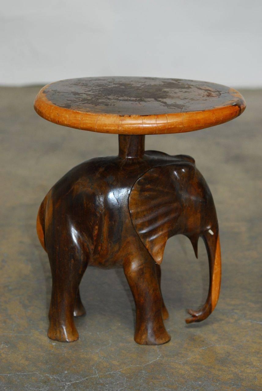 Remarkable pair of hand-carved elephant side tables or stools made from a single piece of saur wood tree trunk in Bali. Each painstakingly made to highlight the natural light outer ring of the tree on the edge of the seat and on the trunk and tail