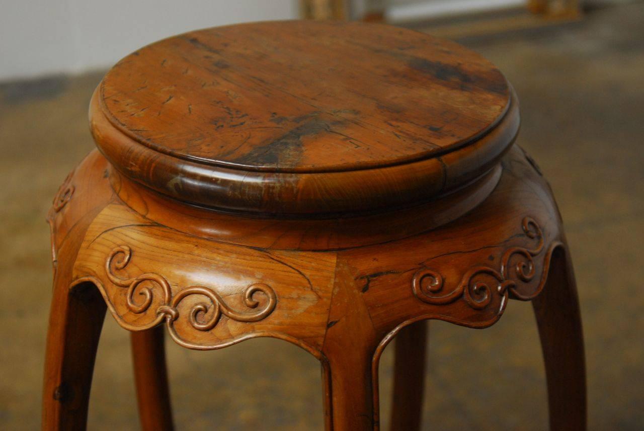 Chinese hand-carved wood pedestal or Stand featuring five unique legs that curl inward and sit on round feet. Conjoined by a ring stretcher on the bottom, this table has a lovely carved apron with a scroll motif and stands 34 inches tall. Finished
