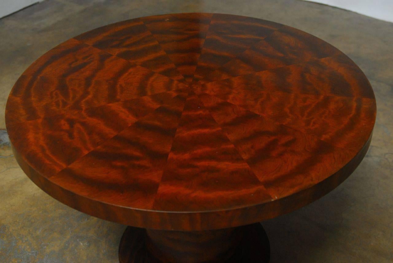Modern pedestal centre table featuring a round top and base. Supported by a thick column and decorated with a geometric radial mahogany veneer in pie-slice shapes. Modern interpretation of Regency style table that could also serve as a breakfast or