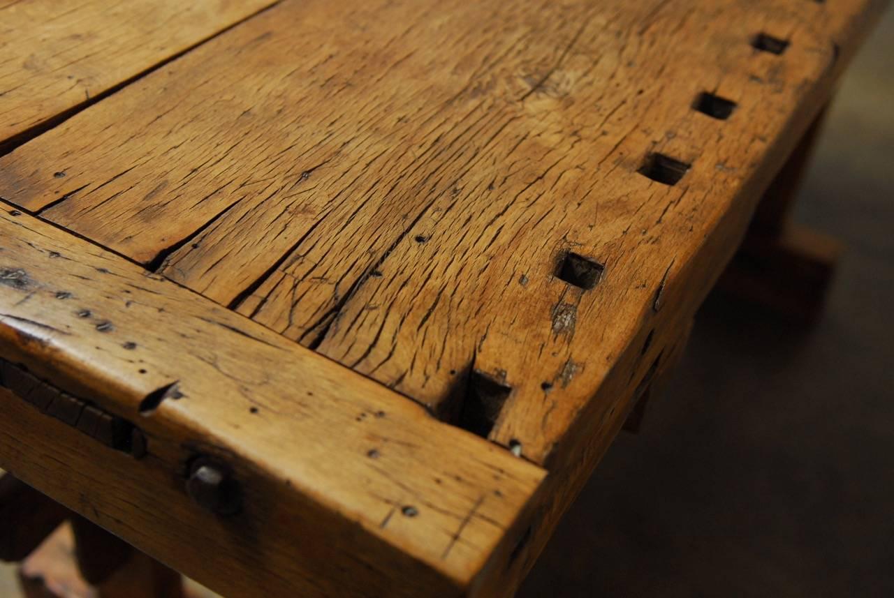 Industrial French Etabli de Menusier made from richly worn elmwood. Featuring exposed mortise and tenon joinery and split wood construction. This carpenter's workbench is an excellent example of both rustic and early Industrial furniture. Built by