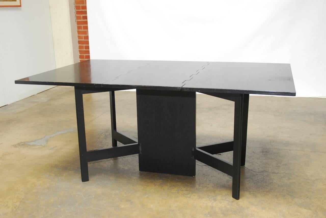 Rare Mid-Century drop-leaf or gate leg dining table designed by George Nelson and associates for Herman Miller. Features an ebonized walnut finish and a unique design that allow the legs to go into multiple configurations that could also serve as a