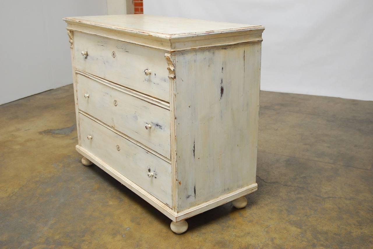 Charming 19th century pine chest of drawers or commode made in the Gustavian taste. Beautifully painted and scraped back to the original cream finish. Large deep drawers bordered by fluted columns on each side and supported by bun feet. Original