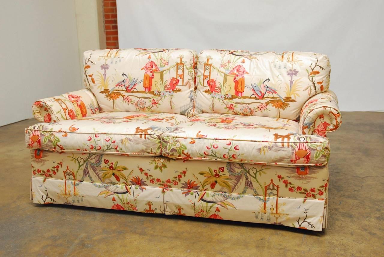 Fantastic English rolled arm settee by Baker furniture featuring Hazelton House Chinese garden chinoiserie fabric made from glazed cotton and hand-printed with a 19th century English "chinois" design pattern. This rare settee has deep