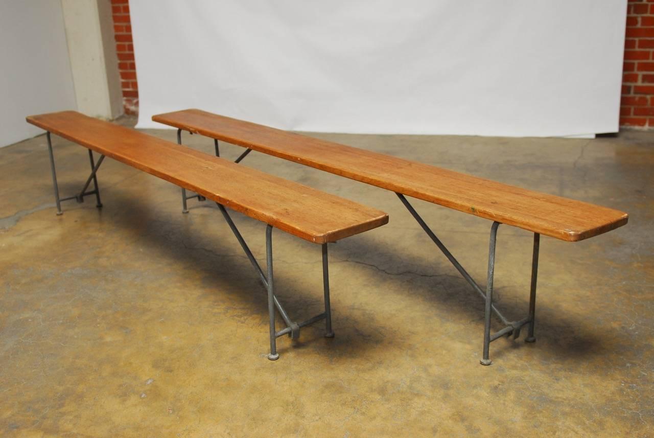 Impressive pair of long naval Campaign benches decommissioned from a U.S. Navy aircraft carrier. Constructed from strong heart pine solid planks 8 feet long featuring steel folding legs with round feet. These benches have a wonderful modern