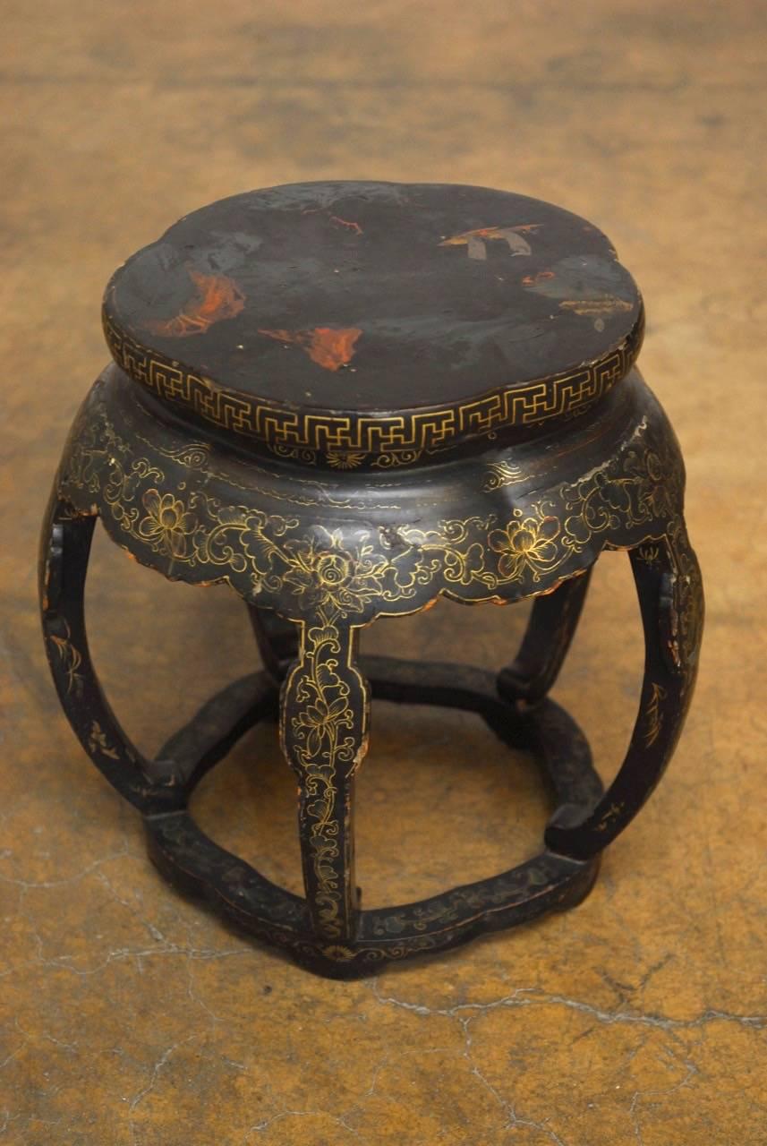 Delicate Chinese black lacquer garden stool or plant stand featuring a vintage polychrome and parcel-gilt finish decorated with foliage and Greek key designs. Supported by five drum shaped legs. With its pedestal form this stool would also make a