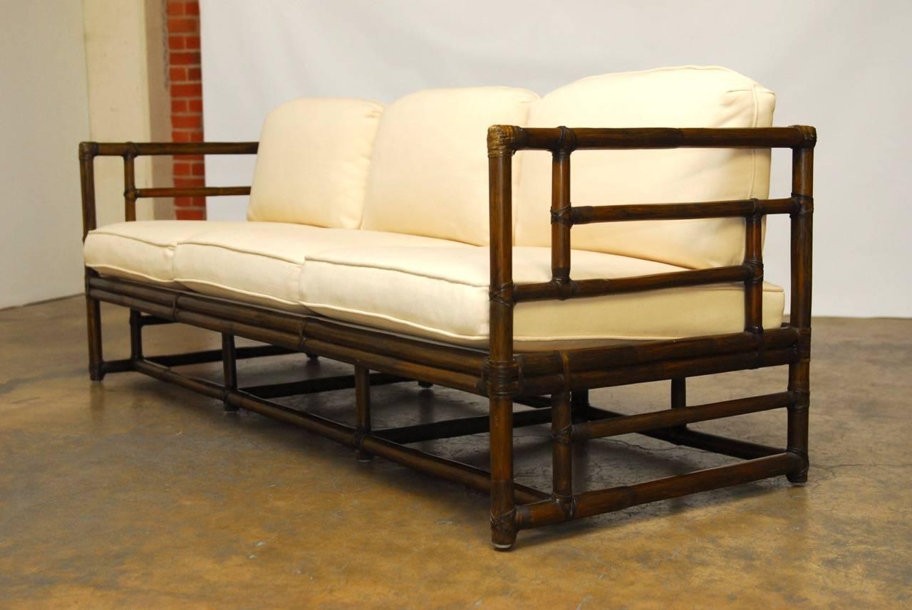 Exceptional bamboo rectangular case style sofa by McGuire featuring an open fretwork frame with rawhide strapping. This sofa showcases the modern use of bamboo by McGuire and becomes a focal point of the room while keeping the piece grounded in