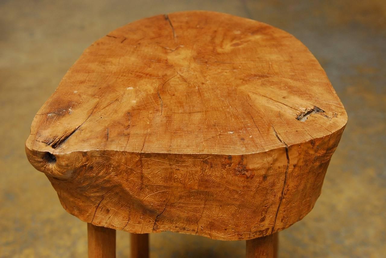 Handcrafted French chopping block table or billot constructed from a solid tree trunk and supported by four hand-hewn legs. Made in an organic primitive style that showcases the natural form trunk. Stable enough to use as a stool.