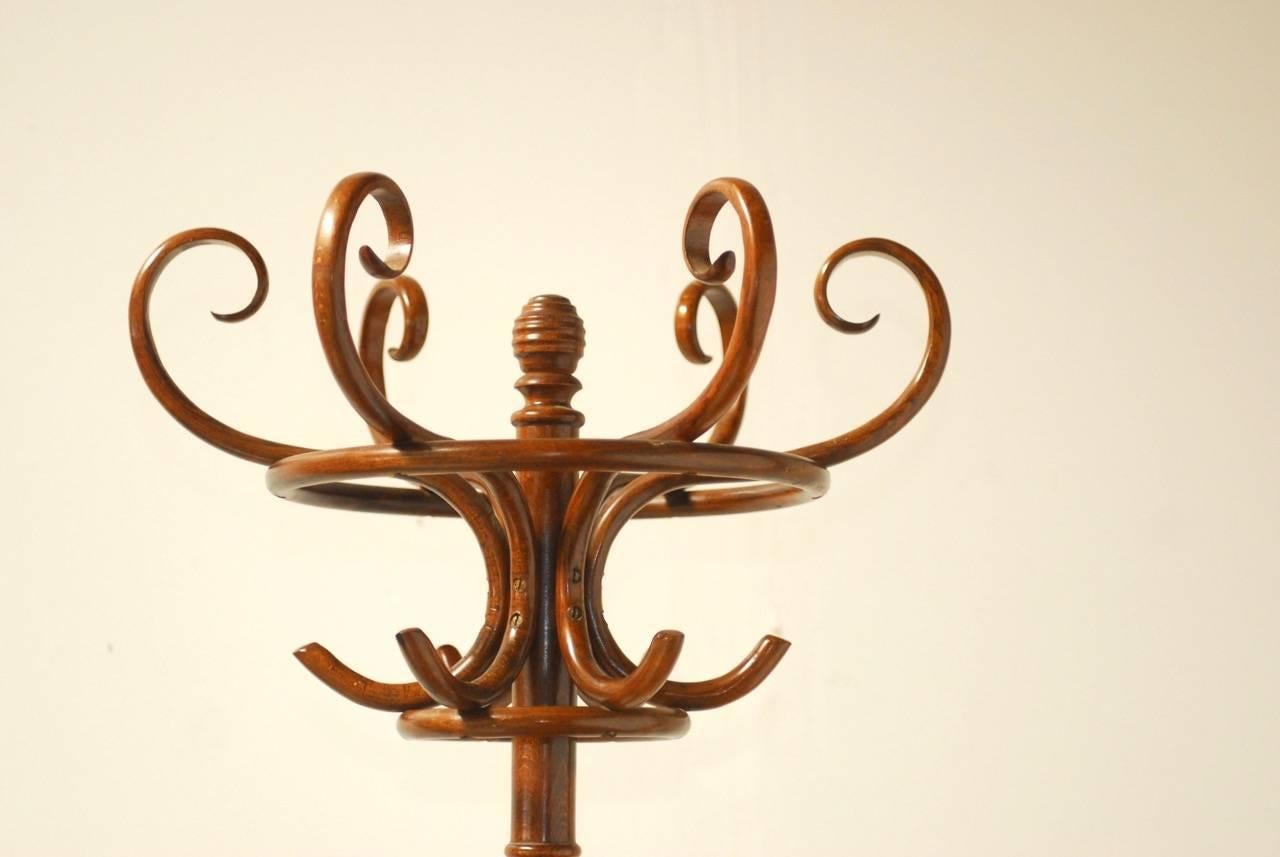 Distinctive bentwood hall tree or coat rack made in the manner of Thonet featuring a swivel turning six double hook top, for a total of 12 hooks and four sections for umbrellas. Classic turn of the century French bistro style topped with a finial.