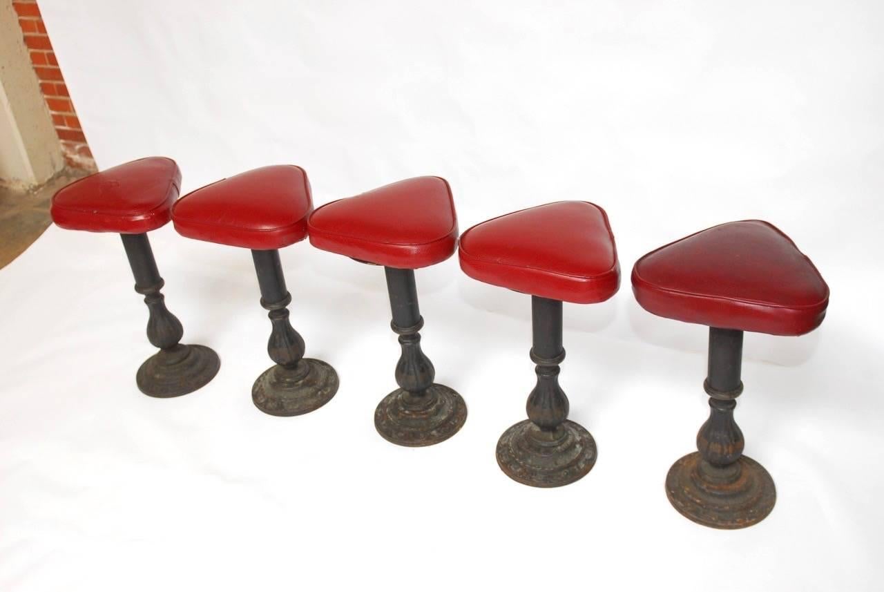 Rare set of five cast iron ice cream parlor style barstools made in the Victorian style featuring a baluster form column with a triangular vinyl seat. Features a beautifully patinated finish. Made by Chromodern Foundry Los Angeles, CA. Provenance: