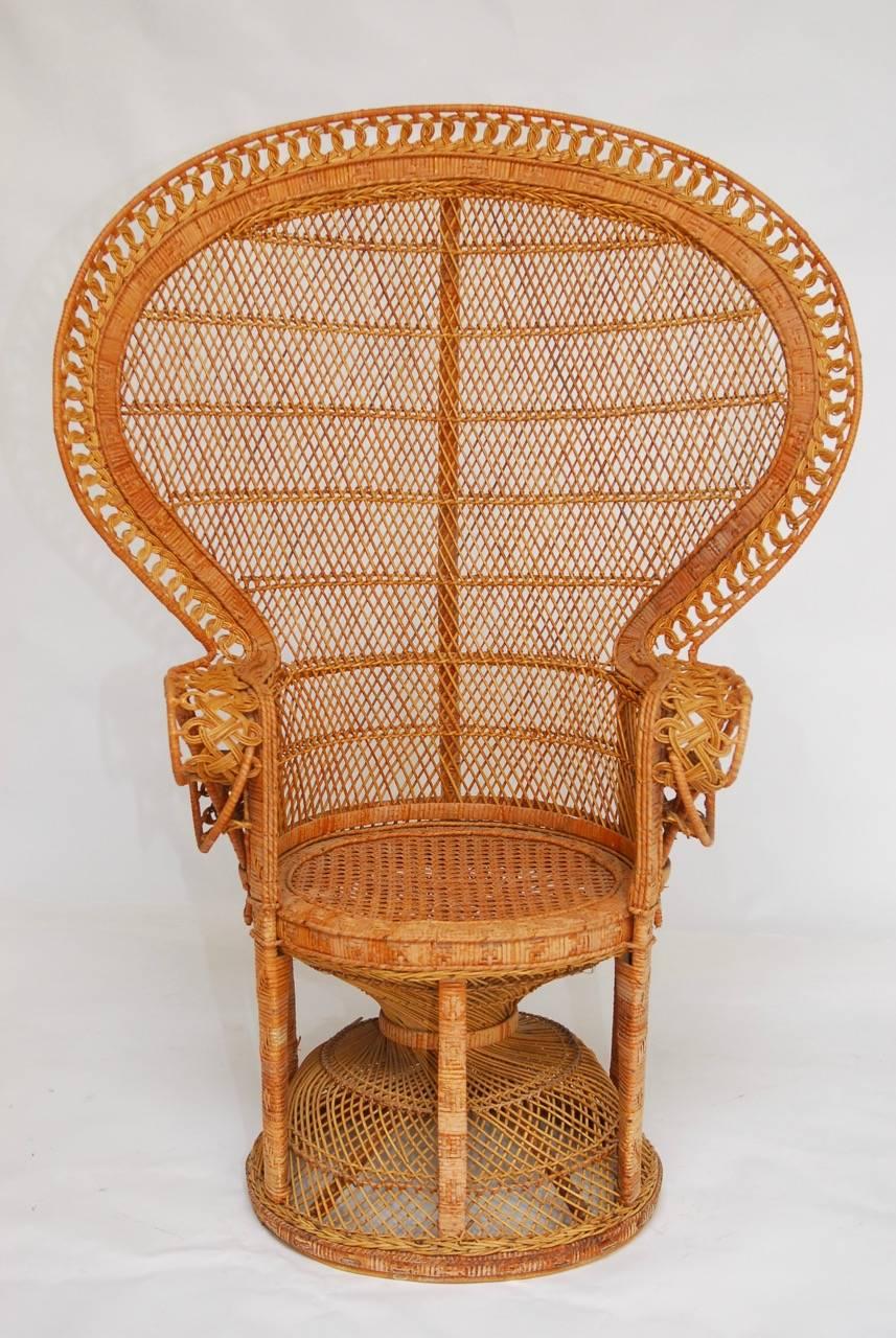 Iconic matched pair of rattan and wicker Emmanuel peacock chairs. Featuring a full fan back, these exceptional handwoven chairs were designed at the height of the Hollywood Regency movement and evoke the spirit of past years glamour.