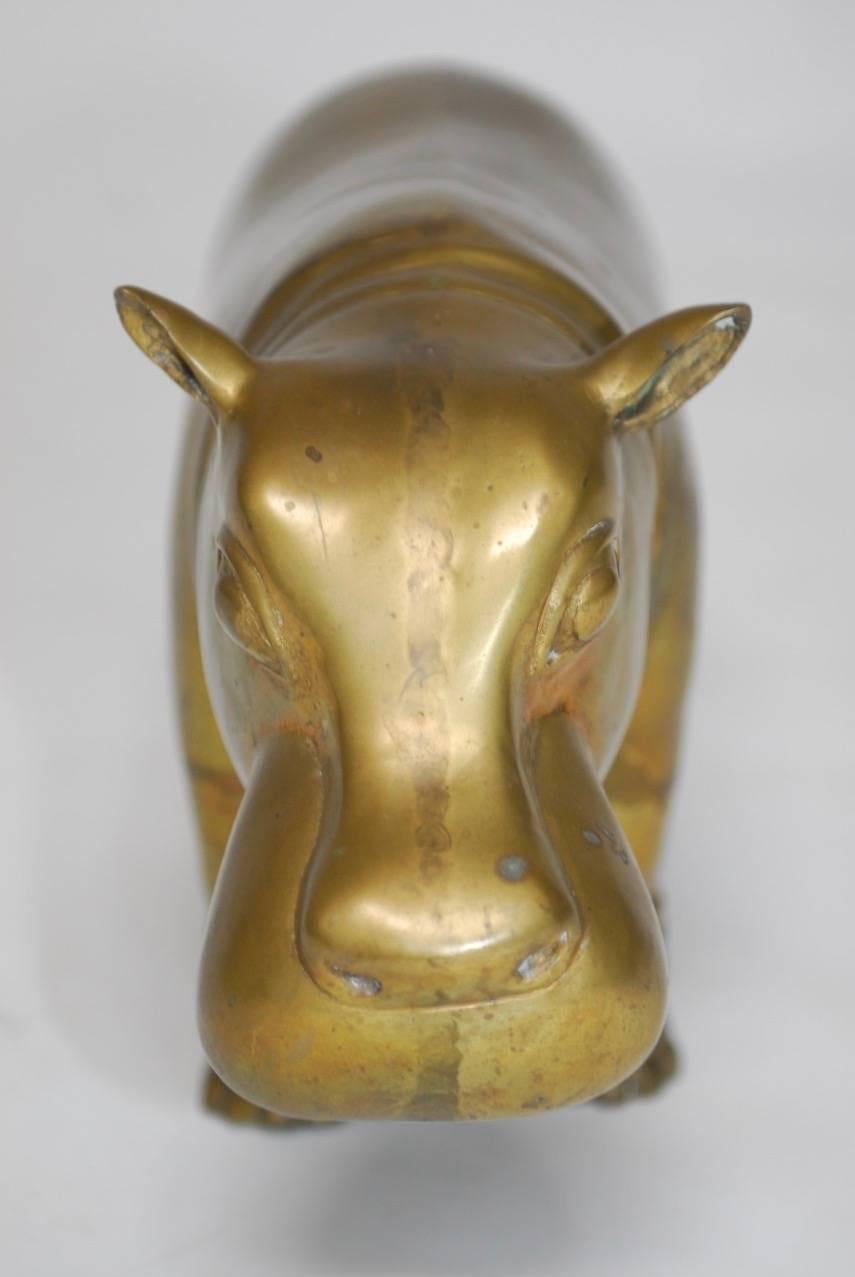 Handmade patinated brass figure of a hippopotamus with a cheerful expression and pointed ears. Large and heavy, weighing over 12 lbs. Would make a good candidate for a door stop. I loved this hippo from the moment I laid eyes on him. He will bring