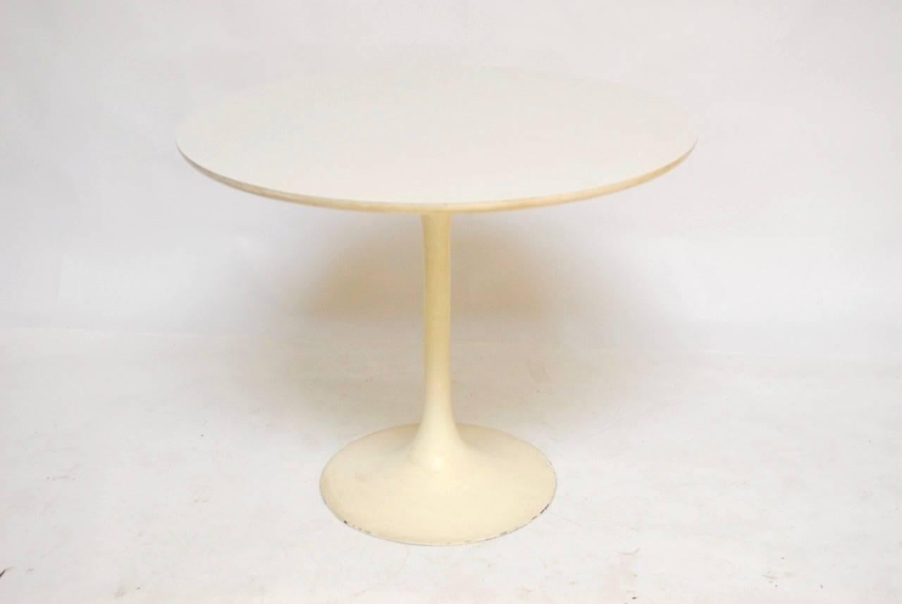 Mid-Century tulip dining table featuring a round laminate white top and an aluminium base with a light cream finish. The top has a beveled edge and a formica round top that compliments the metal base.
