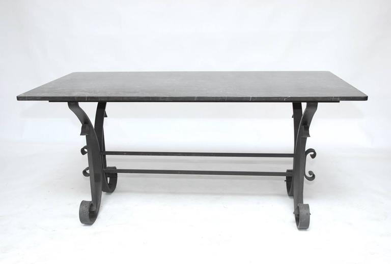 Stunning Italian wrought iron and black marble dining table featuring a scrolled iron base constructed from 2