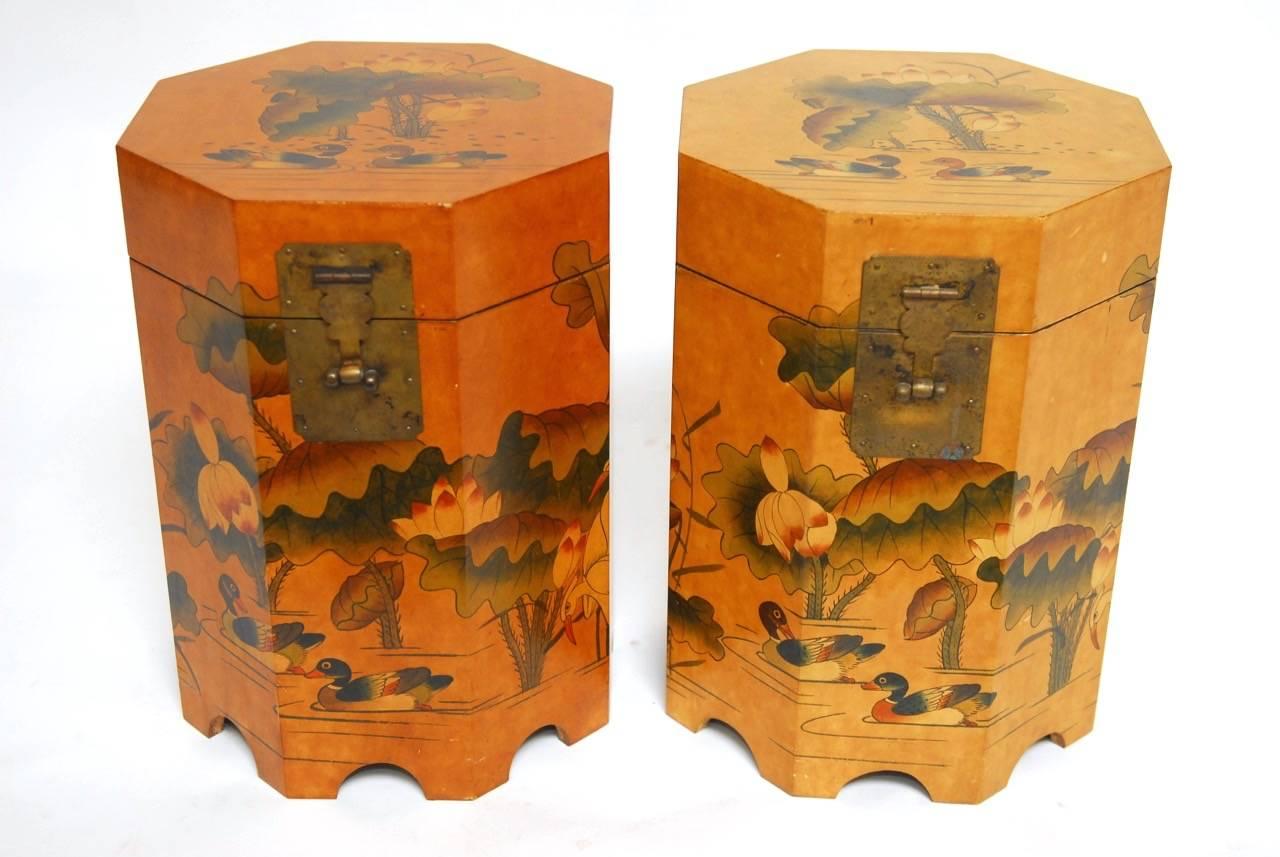 Decorative pair of Chinese octagonal drink tables or side tables featuring a hand-painted lacquer body with a bird and floral motif. These lidded boxes open for storage and are decorated inside with a Chinese script lining. Brass hinges and lock